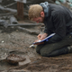 Wood specialist Mike Bamforth examining the base of a two-piece wooden bucket.